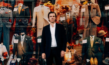Hamilton Leithauser in a suit outside a shopfront selling suits