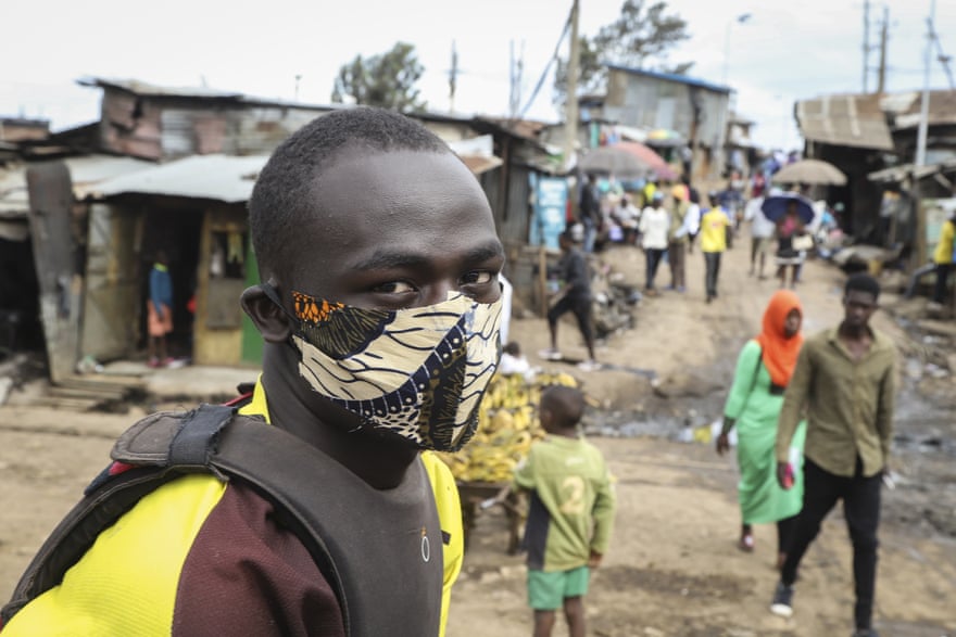 A boda-boda, or motorcycle taxi, driver wears a makeshift mask made from a local fabric known as Kitenge as he looks for customers in the Kibera neighbourhood of Nairobi