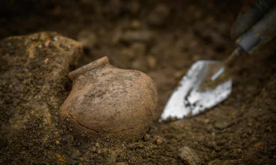 Esing a trowel to unearth artefacts.