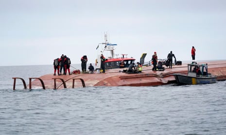 Sea rescue members over the hull of the capsized Danish cargo ship Karin Hoj after it collided with the British cargo ship Scot Carrier in the Baltic Sea.
