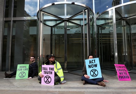 Protesters glue their hands to the ground outside the London Stock Exchange