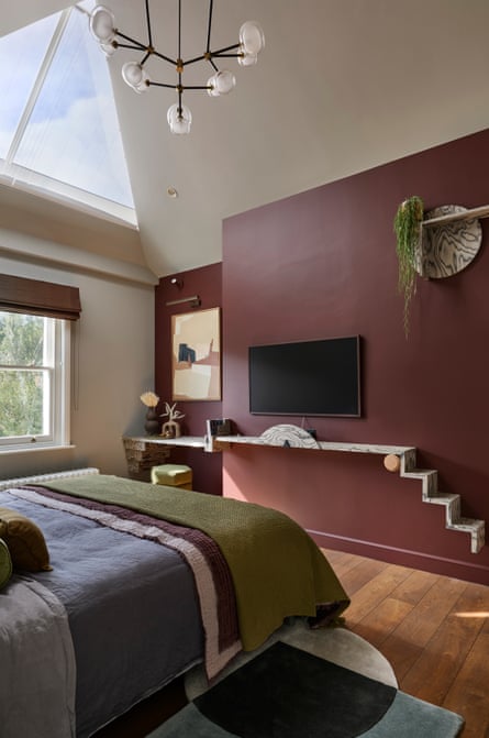 A bedroom with high ceiling and triangular skylight