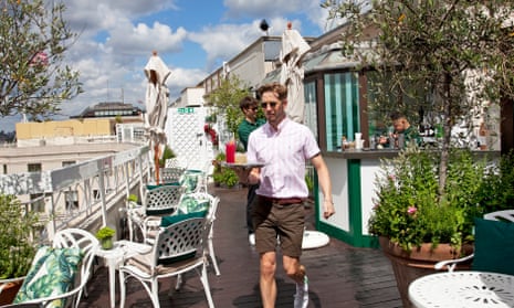 A waiter carrying a tray on the rooftop restaurant
