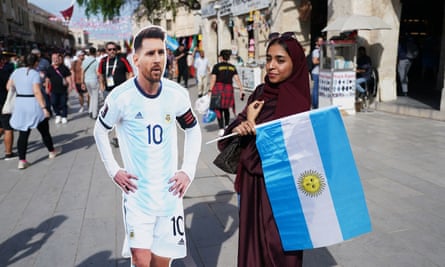 A fan poses for a photo with a cardboard cutout of Argentina's Lionel Messi in Doha.