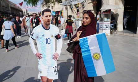 Un fan pose pour une photo avec une découpe en carton de l'Argentin Lionel Messi à Doha.