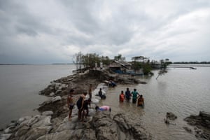 Volunteers and residents work to repair a damaged dam following the landfall of cyclone Amphan in Burigoalini.