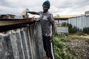Thierno working on repairs to another shack.