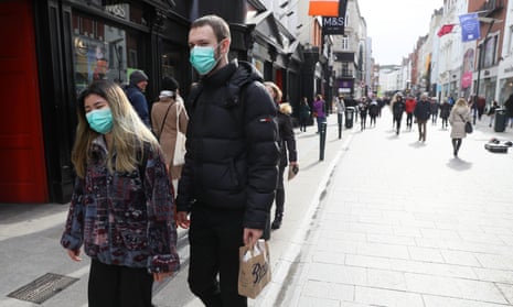 Pedestrians walk along Grafton Street in Dublin, Ireland, wearing masks.