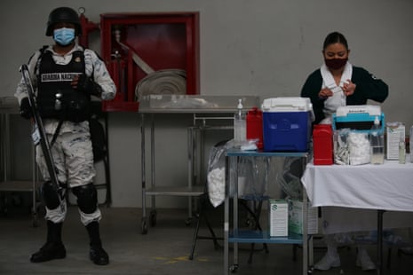 A National Guard officer stands guard as nurse Cristal Ordonez prepares a dose of the Sinovac Covid-19 vaccine at the Americas Cultural Center, in Ecatepec, Mexico, Saturday, on 3 April, 2021.