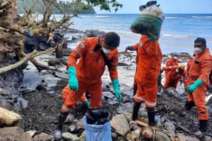 Pola, PhilippinesCoastguard staff and volunteers collect debris covered with oil at a clean-up along the coast in Oriental Mindoro province, days after an oil spill from a sunken tanker