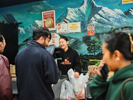 Bhawani Nagarkoti serves customers inside a grocery store