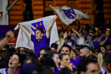 A man holding up the lily flag in a crowd