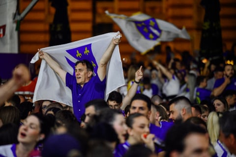 A man holding up the lily flag in a crowd