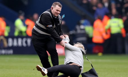 A steward stops a pitch invader during the FA Cup tie