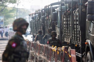 Soldiers in military vehicles stand by as people gather to protest against the military coup, in Yangon, Myanmar, 15 February 2021.