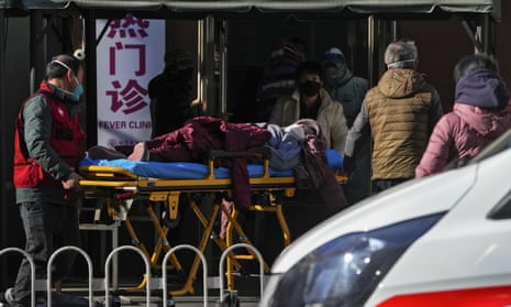 A woman on a stretcher is wheeled into a hospital in Beijing, December 2022