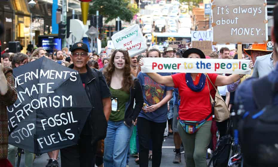 Environmental protesters march down a Brisbane CBD street during morning peak hour in August