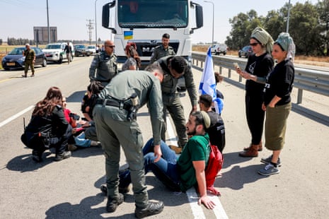 Israeli border guards and police speak with protesters blocking the road to Jordanian trucks carrying humanitarian aid supplies for Gaza on 16 April.