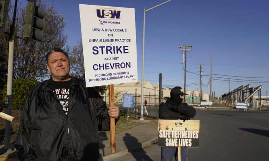 Operator Frank Aguirre, left, stands with a picket sign outside an entrance to the Chevron Corp. refinery, Monday, 21 March, 2022, in Richmond, Calif. More than 500 workers at the refinery in the San Francisco Bay area went on strike early Monday in a contract dispute.