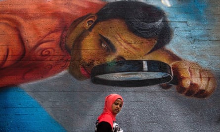 A woman walks past street art in Beirut, Lebanon