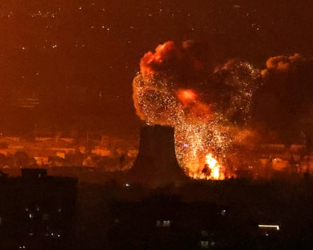 Flames, sparks and billowing smoke surround the silhouette of the Azadi tower.