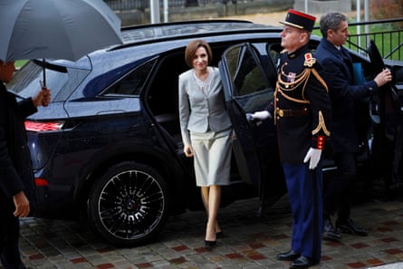 Moldova’s president, Maia Sandu, steps out of the rear door of a car
