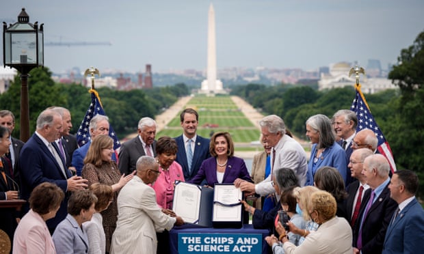 Nancy Pelosi holds up the Chips Act after its passage through Congress.