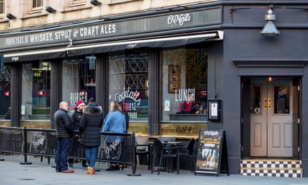 Patrons stand outside an O’Neill’s pub in London