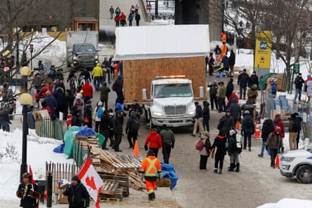 A shed that was being used as a soup kitchen is hauled away as truckers and their supporters continue to protest against the Covid vaccine mandates in Ottawa.