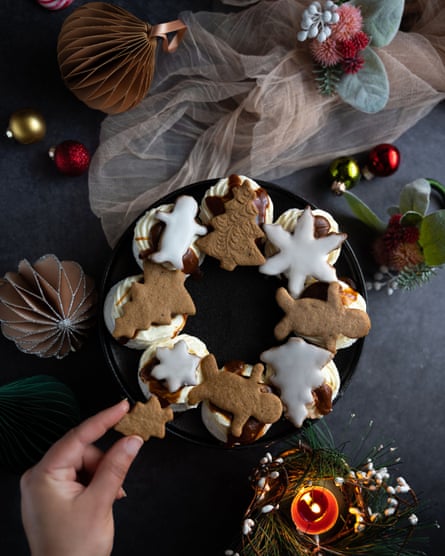 Topview of meringue nests arranged in a circle, topped with gingerbread cookies.