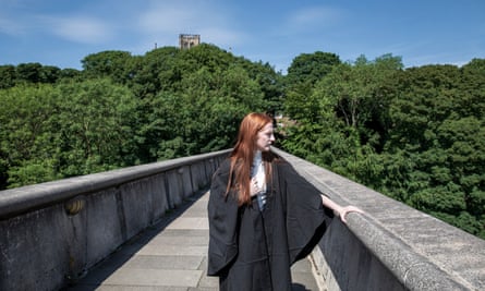 Sophie Corcoran standing on a footbridge wearing a gown