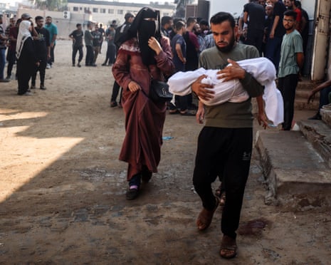 Palestinians mourn by the body of a casualty of Israeli strikes at Al-Shifa hospital in Gaza City, on July 23, 2025.
