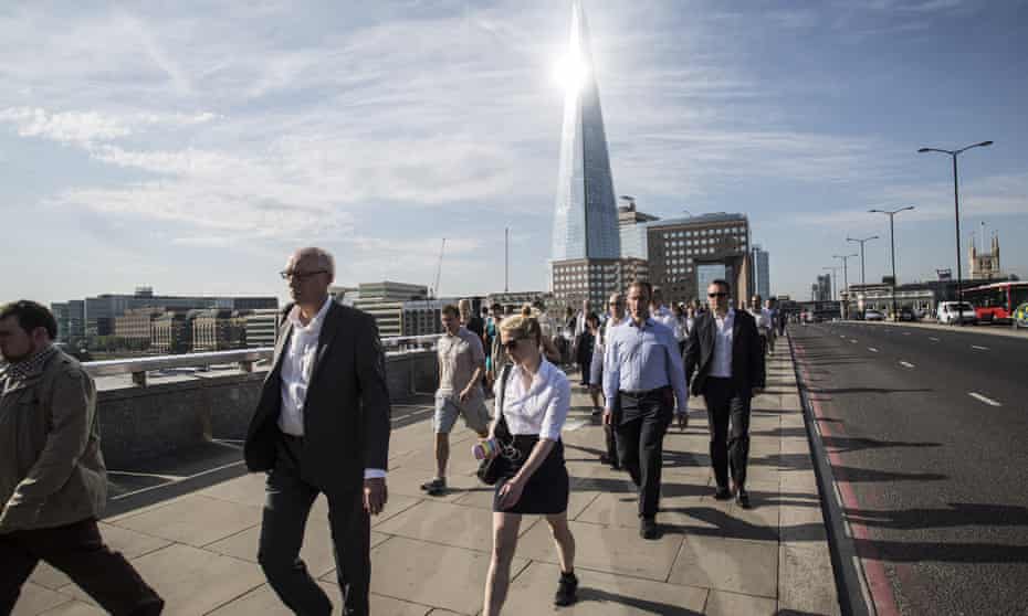 Commuters cross London Bridge into the City of London and the financial district
