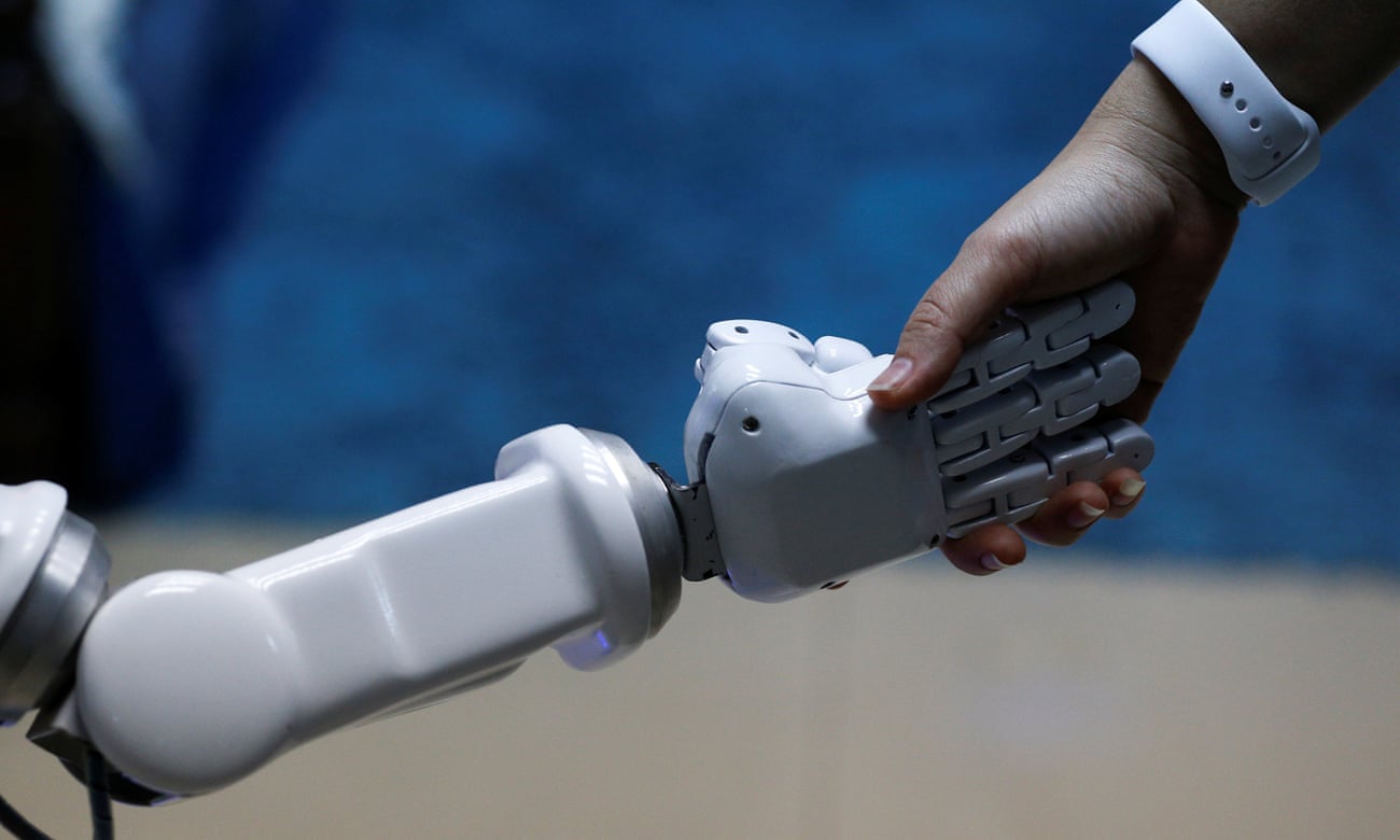 A human shakes a hand of a robot