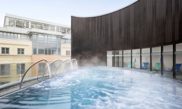 Steam rises from an outdoor rooftop pool
