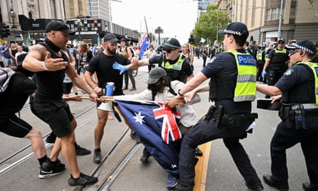 Police grapple with a protester during a transgender rights rally, involving opposing neo-Nazis outside Parliament House in Melbourne