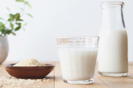 A glass of rice milk, with bowl of rice grain on the side