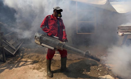 A worker sprays anti-mosquito fog in an attempt to control dengue fever in Jakarta, Indonesia.