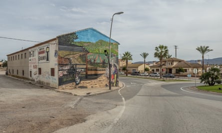 La calle principal a la entrada de un pueblo, con arte con temática agrícola en el costado de un edificio.