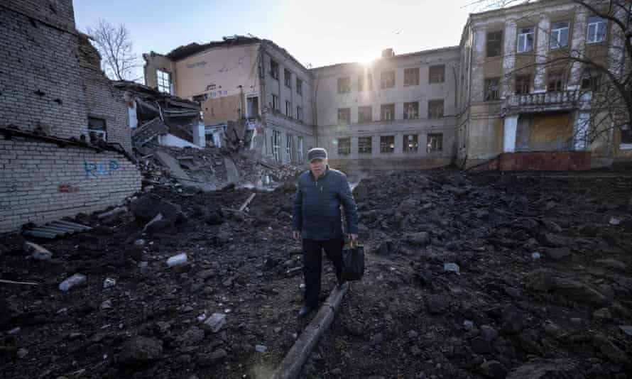 A man walks near a damaged school, next to a police building in Kramatorsk, Donbas.