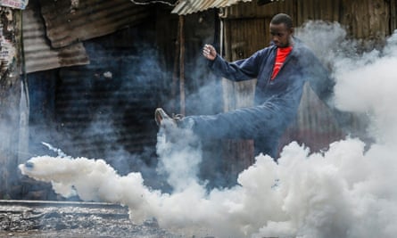 A man kicks away a teargas canister during a protest in Nairobi’s Kibera slum