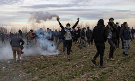 A man picks up a teargas canister fired by police near the Greece-Turkey border.