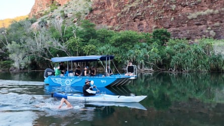 Andy Donaldson swims in the Ord River next to his support kayak and boat