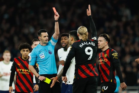 Referee Andy Madley shows a red card to Cristian Romero of Tottenham.