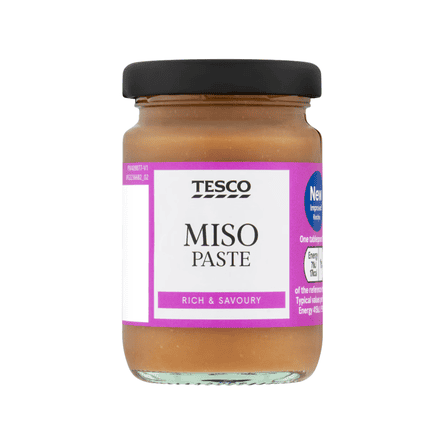 A glass jar with a black lid and purple label reading "Miso Paste" filled with brown paste