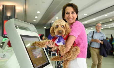 Virgin Australia CEO Jayne Hrdlicka poses with a dog at Melbourne airport on Thursday after the airline announced it wants to allow passengers to bring small cats and dogs onboard flights within 12 months. 