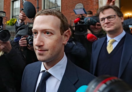 Clegg behind Mark Zuckerberg surrounded by press cameras