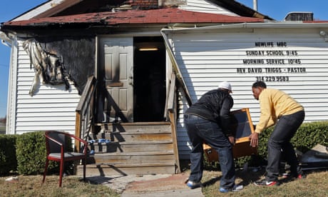 In this Sunday, Oct. 18, 2015 photo, Deacon Clinton McMiller, left, and Pastor David Triggs carry a cabinet back into the church after an outdoor service due to a fire at the New Life Missionary Baptist Church in St. Louis. Someone has been setting fire to predominantly black churches in the St. Louis area, and investigators are trying to determine if the arsonist is targeting either religion or race. (J.B. Forbes/St. Louis Post-Dispatch via AP)  EDWARDSVILLE INTELLIGENCER OUT; THE ALTON TELEGRAPH OUT; MANDATORY CREDIT