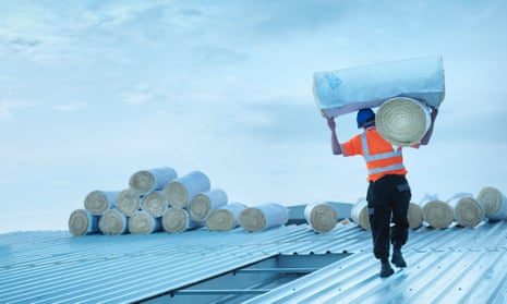 Worker carrying insulation on roof