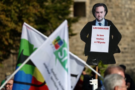 A protester holds a placard depicting French PM, Sebastien Lecornu, with the words ‘bon toutou à l’Elysée’ (the good doggy at the Élysée’).